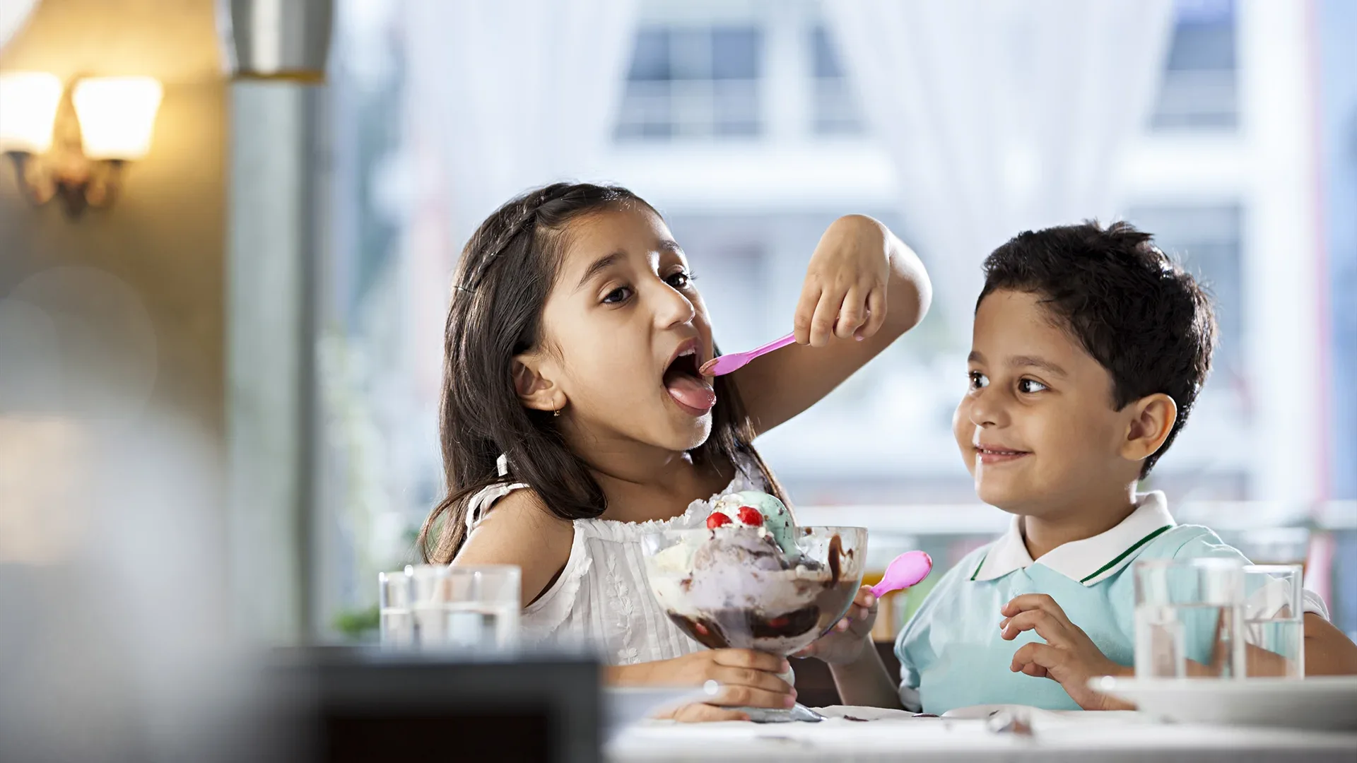 two happy children enjoying a bowl of ice cream